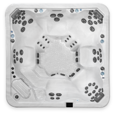 A top-down view of a Clearwater Beachcraft Series empty, white, square hot tub with multiple seating areas and numerous small, black jets spread evenly throughout. There is a step-in area on one side and control buttons visible around the edges. The tub's interior surface is textured.